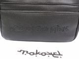 a close up of a black leather bag with a logo on it