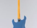 an electric guitar hanging from a string on a wall