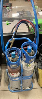 de nombreux types de bouteilles de gaz et de tuyaux éparpillés sur le sol