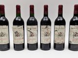 quatre bouteilles de vin sont alignées sur une surface blanche