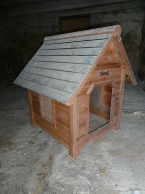 une petite niche en bois au milieu d'un sol en béton
