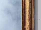 a mirror that has a gold frame on it
