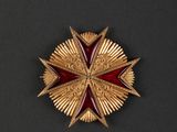 a close up of a red and gold star on a black surface