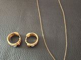 a close up of a necklace and two rings on a table