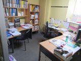 une pièce équipée d'un bureau, d'une chaise, d'une bibliothèque et d'un écran d'ordinateur