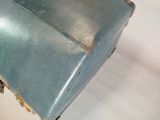 an old blue suitcase sitting on a white surface