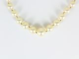 gros plan d'un collier de perles sur une surface blanche