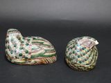 pair of ceramic figurines of a peacock and a bird on a black background