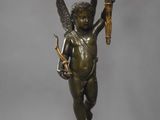 bronze statue of a cupid holding a torch on top of a golden ball