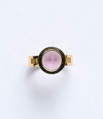 une image d'une bague en or avec une pierre rose au centre