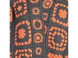 a close up of an orange and black crochet cardigan