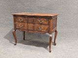 a small wooden chest of drawers on a table