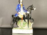 une figurine représentant un homme à cheval sur un rocher
