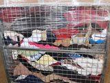 a cart with a lot of clothes on it in a warehouse
