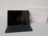 a black laptop with a blue keyboard next to a white box