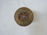 brass plate with a turquoise and red stone in the center