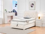 a white bed in a white room with a fireplace