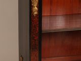 a black and gold bookcase with a clock on top of it