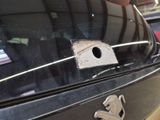 a birdhouse on the back of a car in a parking lot