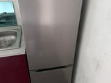 a silver refrigerator and sink in a small room