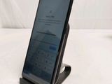 a close up of a cell phone on a stand on a white surface