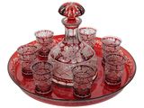 un plateau rouge sur lequel sont posés une carafe en verre et des verres