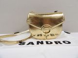 the gold handbag is sitting on top of a white box