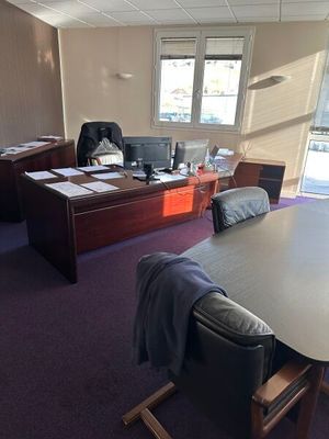 une grande table et des chaises dans un bureau donnant sur l'extérieur