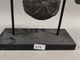 an image of a sculpture of a person holding a bell on a stand