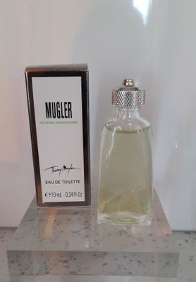 un flacon d'eau de Cologne posé sur une table à côté d'un coffret de parfum