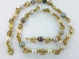 a close up of a necklace with pearls on a white background