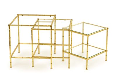 trois tables d'appoint en métal doré et en verre sur fond blanc