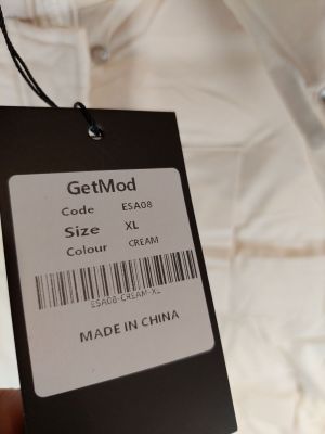 Quelqu'un tient une étiquette sur laquelle est écrit « Getmod taille XXL ».