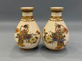 pair of chinese vases with figures on them on a table