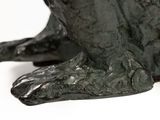 a close up of a statue of a dog on a white surface