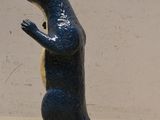 une petite statue bleue représentant un ours debout sur ses pattes arrière