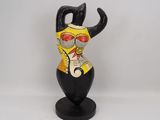 statue of a black cat with a yellow shirt and red glasses