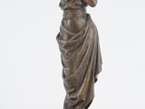 bronze statue of a woman holding a bird on a stone base
