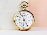 a close up of a gold pocket watch on a table