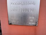 a metal plaque on the side of a pink building