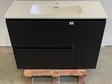 a black vanity with a white sink and a wooden pallet