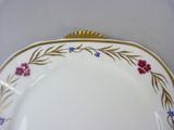 a white plate with a gold rim and flowers on it
