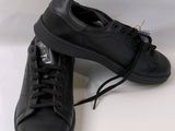 black leather sneakers with black laces on a white background