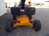a picture of a small yellow tractor parked in a parking lot