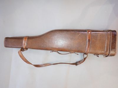 un vieil étui à arme repose sur une surface blanche