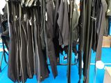 de nombreuses vestes suspendues à un portant dans une pièce