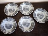 four plates with black and white designs on them on a wooden table