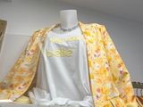 a white shirt with yellow flowers on it sitting on a table