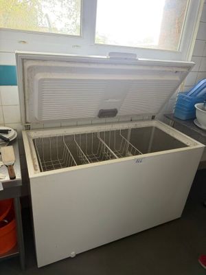 a white chest freezer sitting in a kitchen next to a window