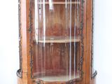 a wooden cabinet with a glass door in the corner